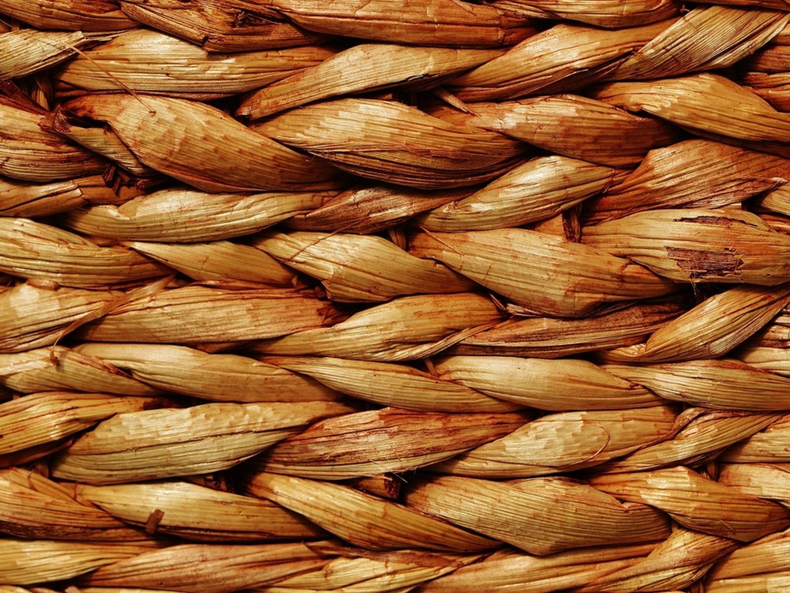 Close view of rattan strips woven over and under in a tight, regular weave