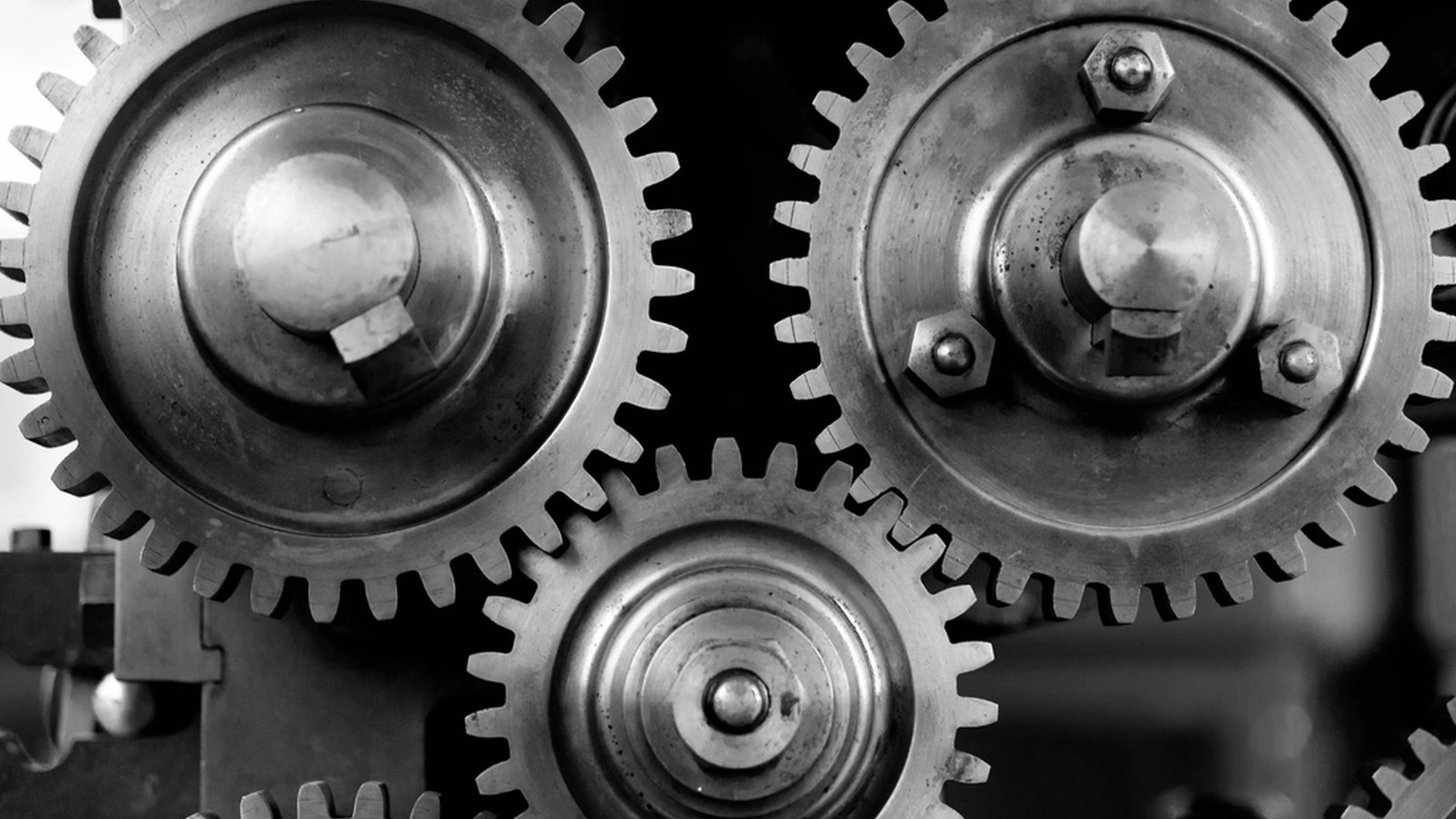 Three steel gears meshed together, teeth interlocking