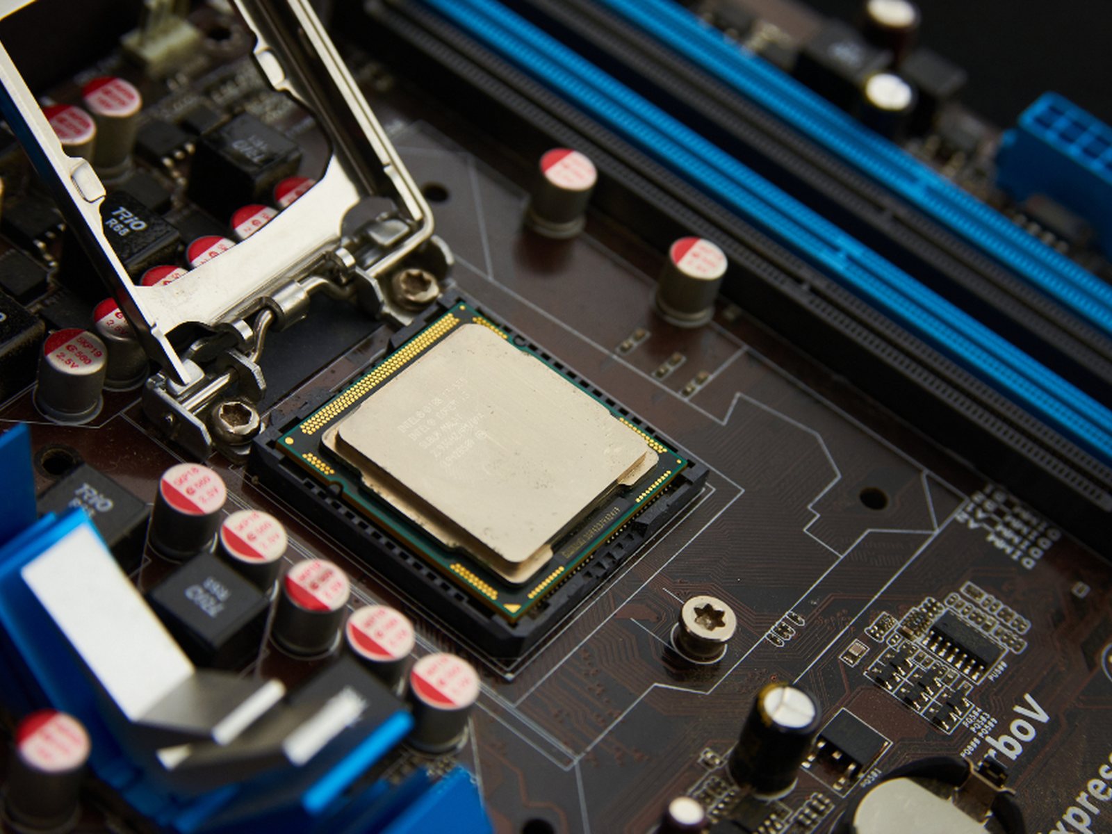 A motherboard with a processor seated in its socket and memory slots alongside