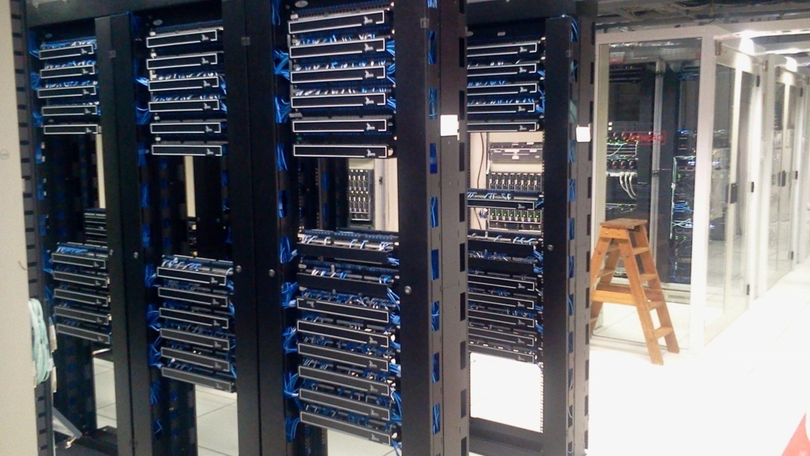 Rows of rack-mounted servers in a machine room, cabling running down the front