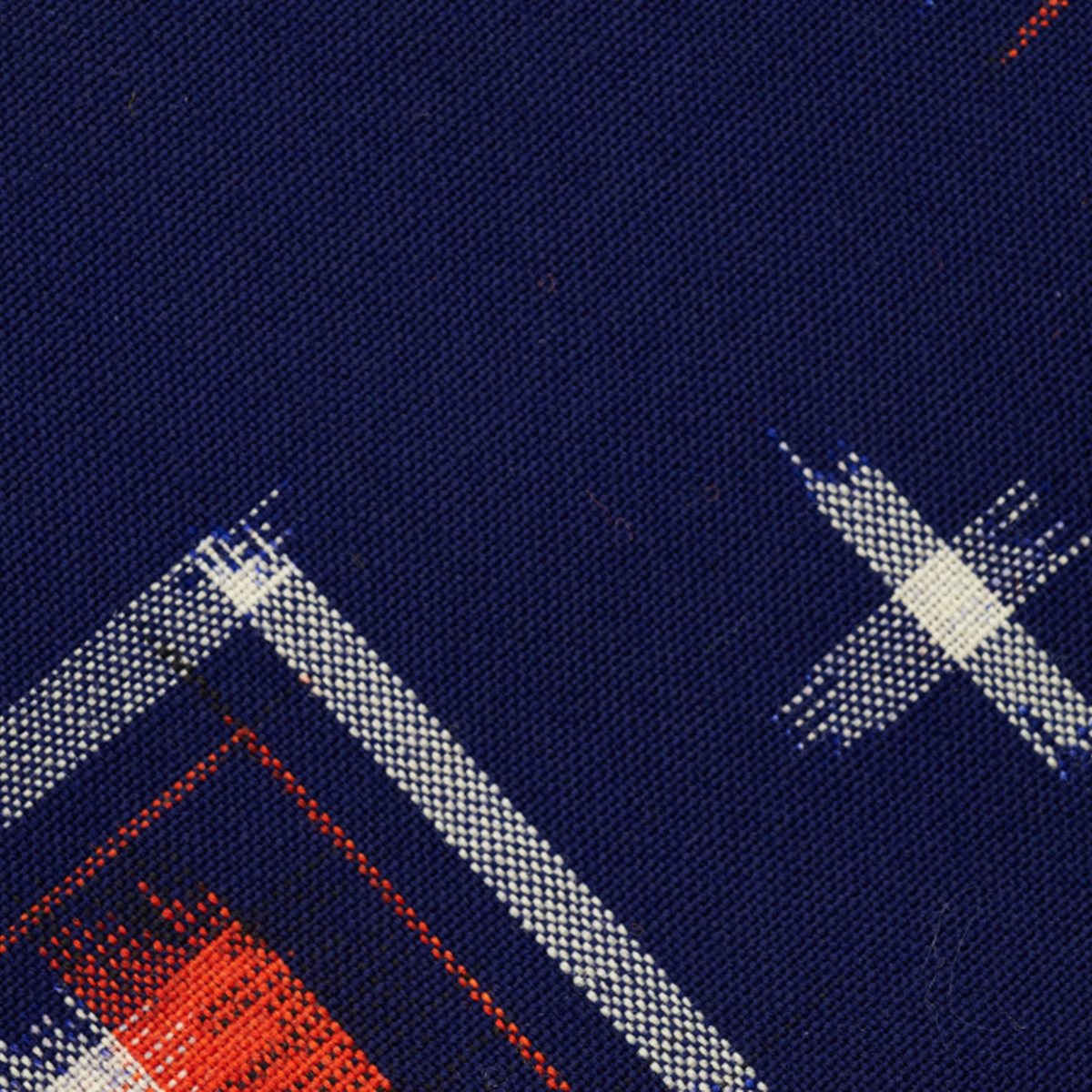 A woven textile in deep navy, pale threads crossing in diagonal bands with a stripe of red